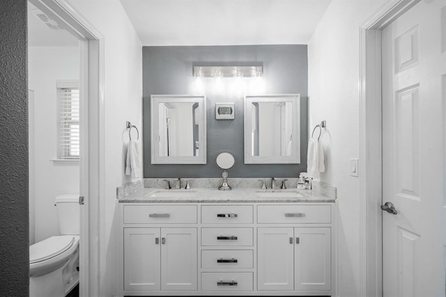 full bath featuring toilet and double vanity