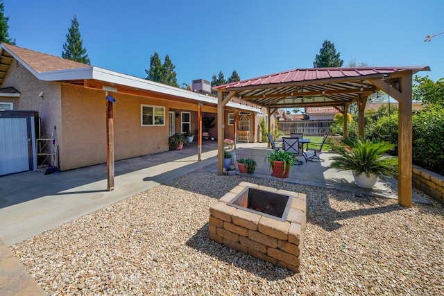 view of patio featuring a fire pit, a gazebo, and fence