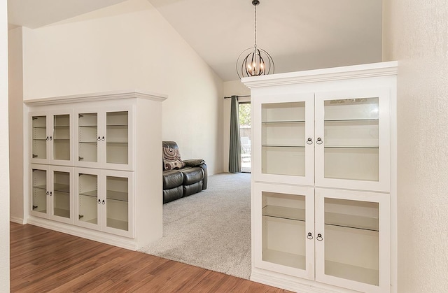 interior space with vaulted ceiling, wood finished floors, and a chandelier