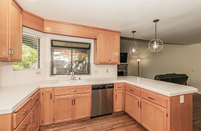 kitchen with dishwasher, backsplash, a peninsula, and a sink