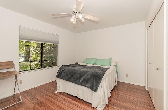 bedroom with wood finished floors, a ceiling fan, and baseboards