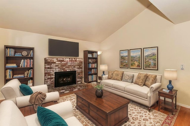 living area with baseboards, vaulted ceiling, wood finished floors, and a brick fireplace