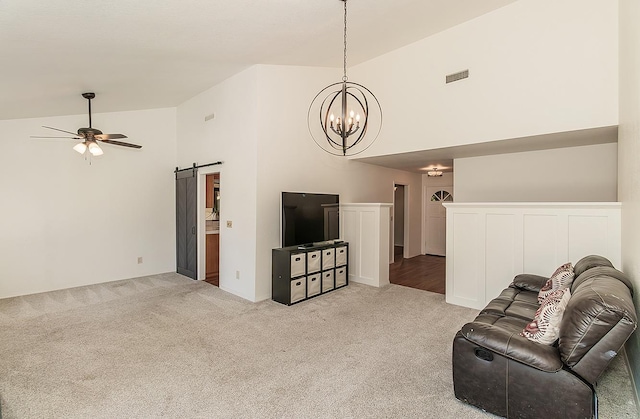 unfurnished living room featuring a barn door, visible vents, carpet flooring, high vaulted ceiling, and ceiling fan with notable chandelier