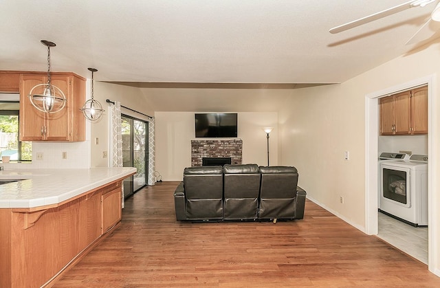 living area featuring separate washer and dryer, a healthy amount of sunlight, and light wood-style floors