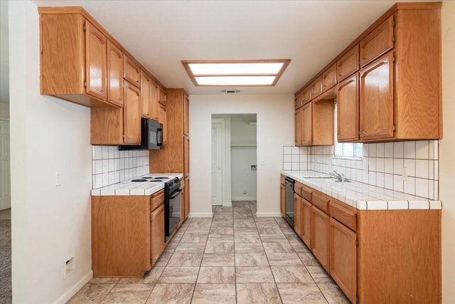 31200 Revis Rd, Coarsegold, CA 93614 - kitchen featuring tile countertops, visible vents, black appliances, a sink, and decorative backsplash