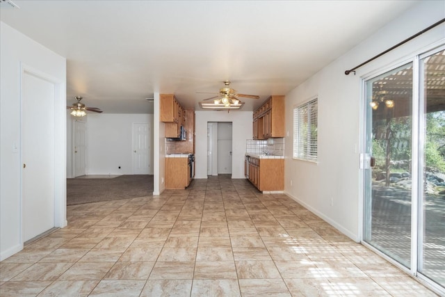 31200 Revis Rd, Coarsegold, CA 93614 - kitchen with decorative backsplash, ceiling fan, light countertops, and stainless steel range with gas stovetop