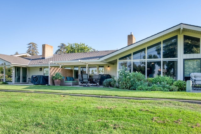7560 N Charles Ave Unit C, Fresno, CA 93711 - back of house featuring board and batten siding, a yard, and a chimney