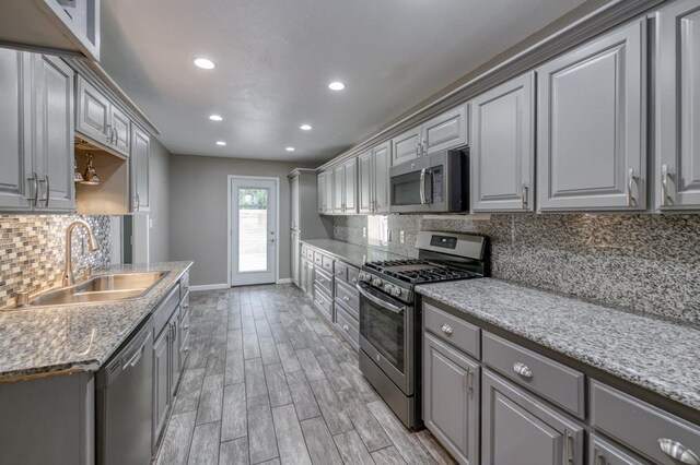 7560 N Charles Ave Unit C, Fresno, CA 93711 - kitchen featuring appliances with stainless steel finishes, a sink, light wood finished floors, baseboards, and gray cabinetry