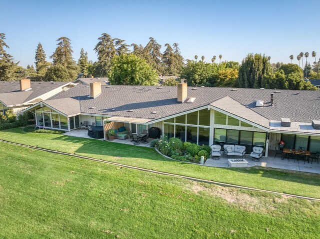 7560 N Charles Ave Unit C, Fresno, CA 93711 - rear view of property featuring an outdoor hangout area, a sunroom, a chimney, a patio, and a yard