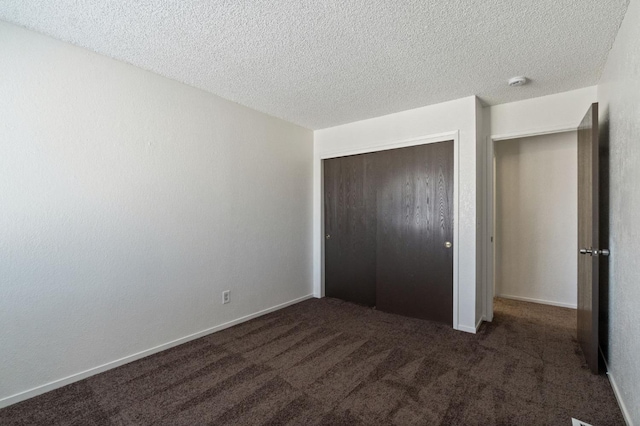 unfurnished bedroom featuring a closet, carpet flooring, and a textured ceiling