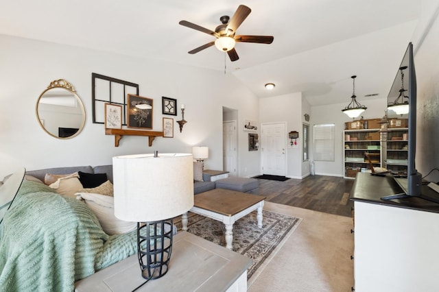 living room featuring a ceiling fan, wood finished floors, and vaulted ceiling