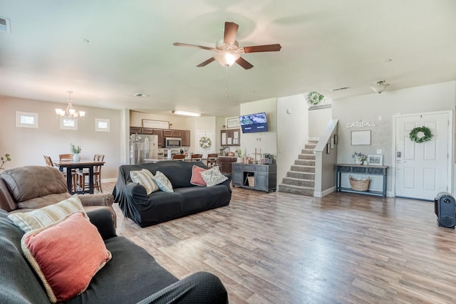 2960 3rd St, Sanger, CA 93657 - living room with a chandelier, a ceiling fan, light wood-style flooring, stairway, and baseboards