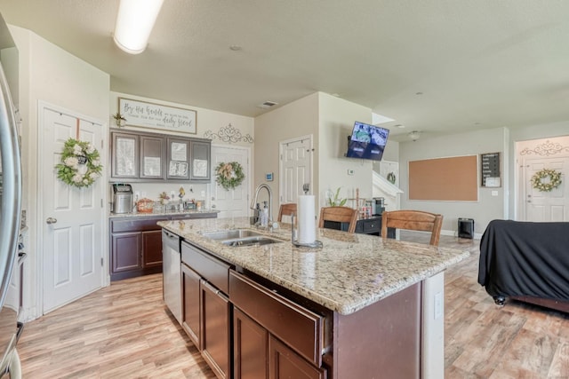 2960 3rd St, Sanger, CA 93657 - kitchen featuring a sink, appliances with stainless steel finishes, light wood-type flooring, light stone counters, and a kitchen island with sink