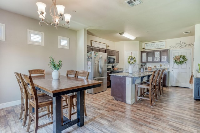 2960 3rd St, Sanger, CA 93657 - dining space featuring light wood-style floors, a chandelier, and baseboards