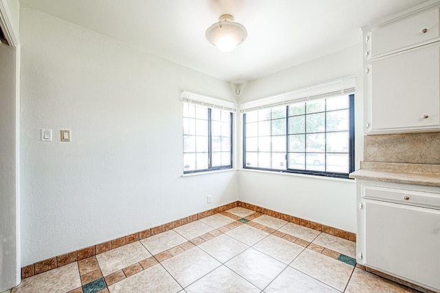 3907 E Dayton Ave, Fresno, CA 93726 - unfurnished dining area with baseboards and light tile patterned floors