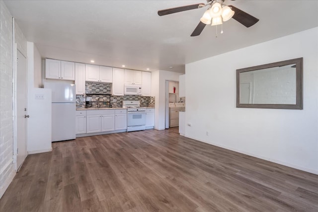kitchen with white appliances, light countertops, white cabinetry, decorative backsplash, and wood finished floors