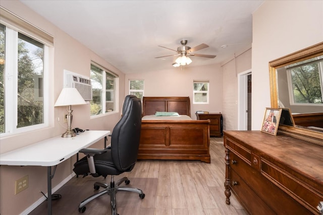 office featuring light wood-type flooring, a wall mounted AC, baseboards, and a ceiling fan