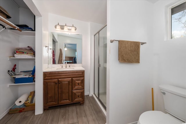 full bathroom with a shower stall, toilet, and wood finished floors