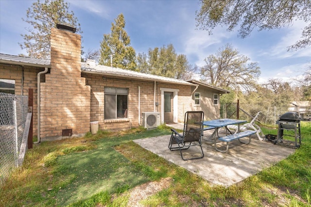 rear view of house with ac unit, a lawn, a patio area, metal roof, and a chimney