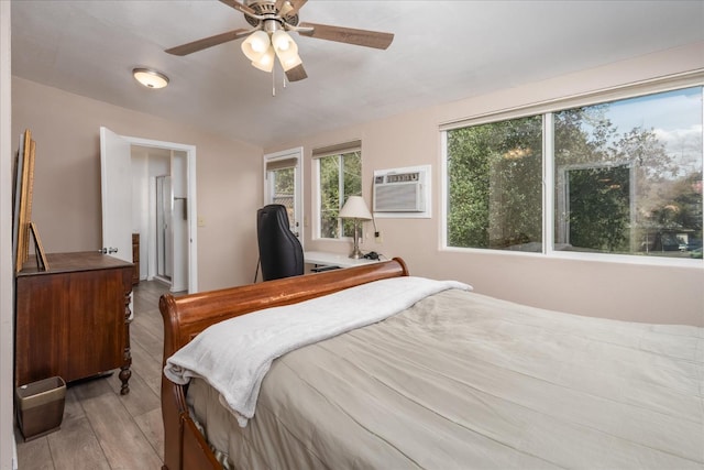 bedroom featuring a ceiling fan, light wood-type flooring, and an AC wall unit