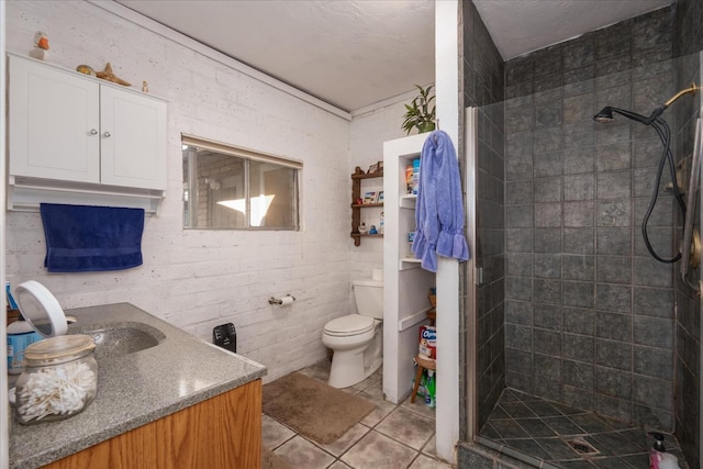 full bathroom with tile patterned flooring, vanity, a tile shower, and toilet