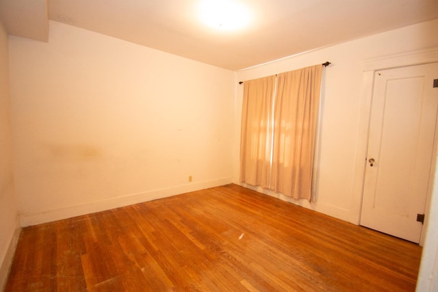 unfurnished room featuring baseboards and wood finished floors