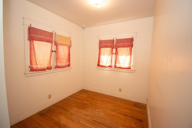 empty room featuring wood finished floors and baseboards