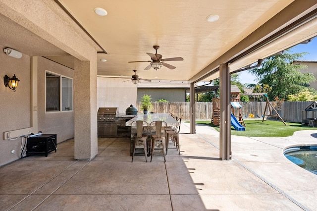 1905 E Via Fiore Ave, Fresno, CA 93730 - view of patio featuring a fenced backyard, a playground, outdoor dining area, and an outdoor kitchen
