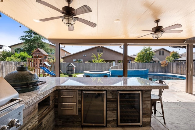 1905 E Via Fiore Ave, Fresno, CA 93730 - view of patio with an outdoor kitchen, a fenced backyard, beverage cooler, and a playground