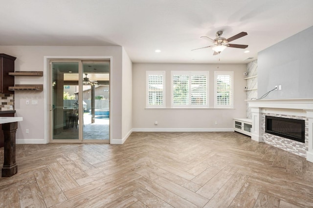 1905 E Via Fiore Ave, Fresno, CA 93730 - unfurnished living room with a stone fireplace, ceiling fan, and baseboards