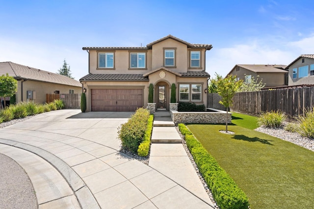 1905 E Via Fiore Ave, Fresno, CA 93730 - mediterranean / spanish-style home with an attached garage, concrete driveway, a tile roof, fence, and stucco siding