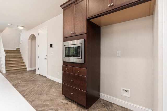 1905 E Via Fiore Ave, Fresno, CA 93730 - kitchen featuring light countertops, stainless steel microwave, arched walkways, and baseboards