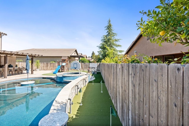 1905 E Via Fiore Ave, Fresno, CA 93730 - view of swimming pool featuring a fenced backyard, a pool with connected hot tub, a playground, and a patio area