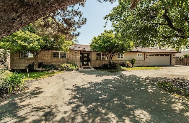 9798 S Thompson, Selma, CA 93662 - view of front facade featuring an attached garage, a tiled roof, brick siding, and driveway