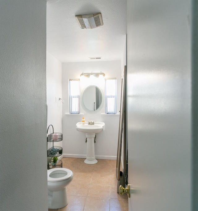 bathroom featuring tile patterned floors, baseboards, toilet, and visible vents