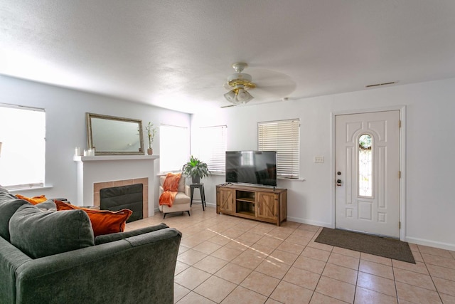 living area with plenty of natural light, ceiling fan, and light tile patterned floors