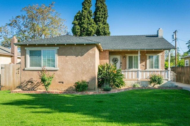 view of front of house with stucco siding, a front lawn, fence, and covered porch