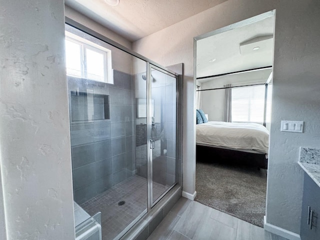 3395 Las Rosas Ave, Clovis, CA 93619 - ensuite bathroom with a shower stall, a textured wall, and wood finished floors