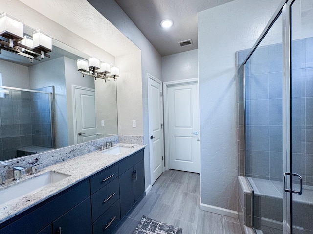3395 Las Rosas Ave, Clovis, CA 93619 - full bathroom featuring double vanity, a stall shower, wood finished floors, and a chandelier