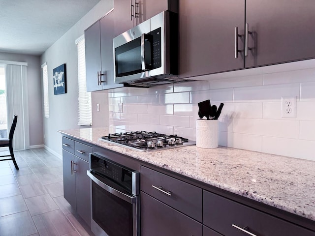 3395 Las Rosas Ave, Clovis, CA 93619 - kitchen featuring appliances with stainless steel finishes, tasteful backsplash, and light stone countertops