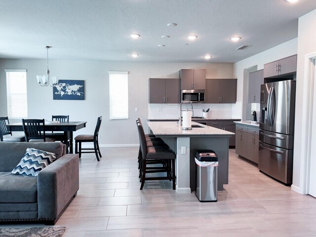 3395 Las Rosas Ave, Clovis, CA 93619 - kitchen featuring appliances with stainless steel finishes, gray cabinets, a chandelier, healthy amount of natural light, and recessed lighting