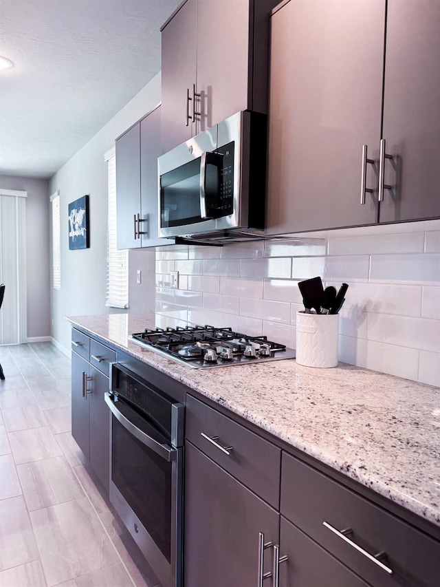 3395 Las Rosas Ave, Clovis, CA 93619 - kitchen featuring stainless steel appliances, decorative backsplash, and light stone counters