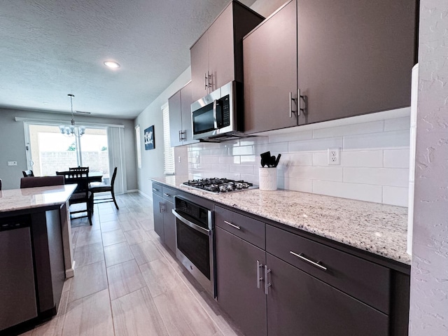 3395 Las Rosas Ave, Clovis, CA 93619 - kitchen with appliances with stainless steel finishes, tasteful backsplash, a chandelier, a textured ceiling, and hanging light fixtures