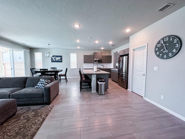 3395 Las Rosas Ave, Clovis, CA 93619 - living area featuring a textured ceiling, recessed lighting, and a chandelier