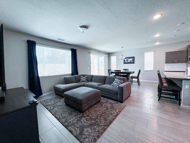 3395 Las Rosas Ave, Clovis, CA 93619 - living area featuring plenty of natural light, a textured ceiling, recessed lighting, a chandelier, and light wood-type flooring