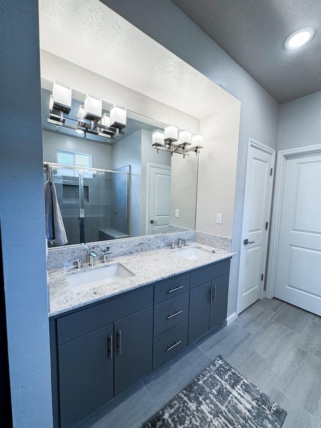 3395 Las Rosas Ave, Clovis, CA 93619 - bathroom featuring double vanity, a stall shower, a textured ceiling, and a chandelier