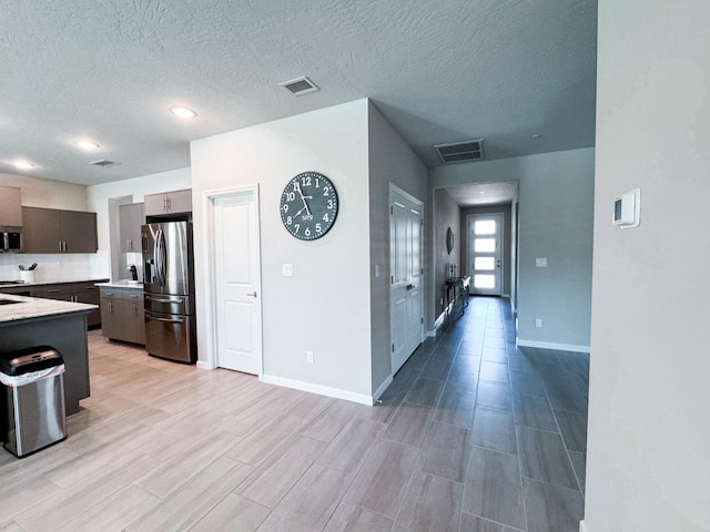 3395 Las Rosas Ave, Clovis, CA 93619 - kitchen featuring appliances with stainless steel finishes, light countertops, a textured ceiling, and light wood-style flooring