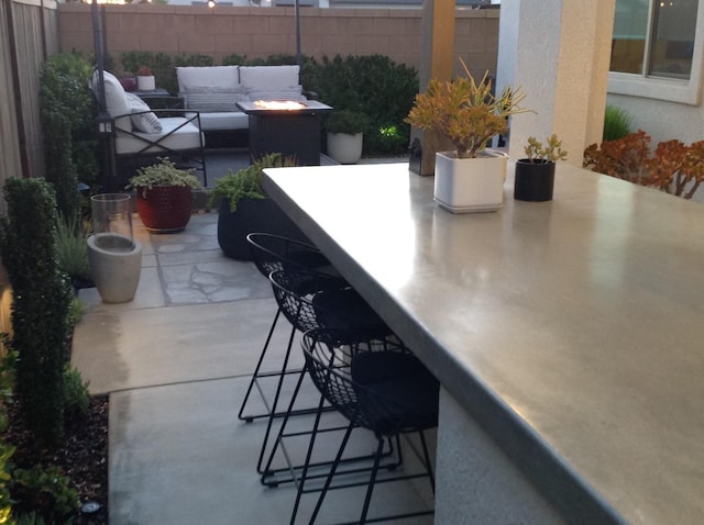 view of patio featuring an outdoor living space, outdoor dry bar, and fence