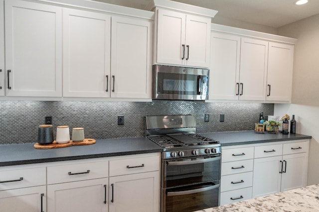 kitchen featuring stainless steel appliances, white cabinetry, and decorative backsplash