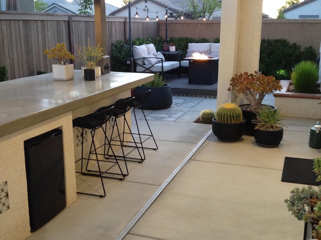 view of patio / terrace with an outdoor living space with a fire pit, outdoor dry bar, and a fenced backyard